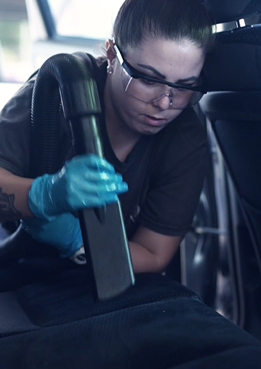 Mujer limpiando un automobil